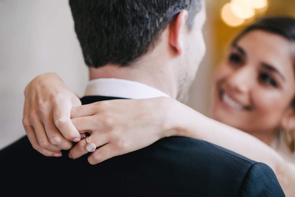 A bride and groom putting their wedding rings on each other.