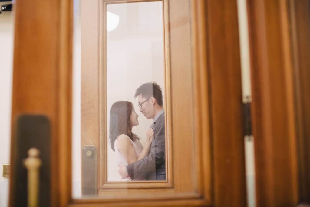 An asian couple embracing in a doorway.