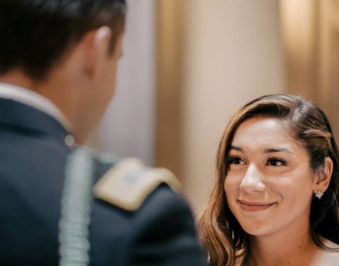 A woman is smiling at a man in a military uniform.